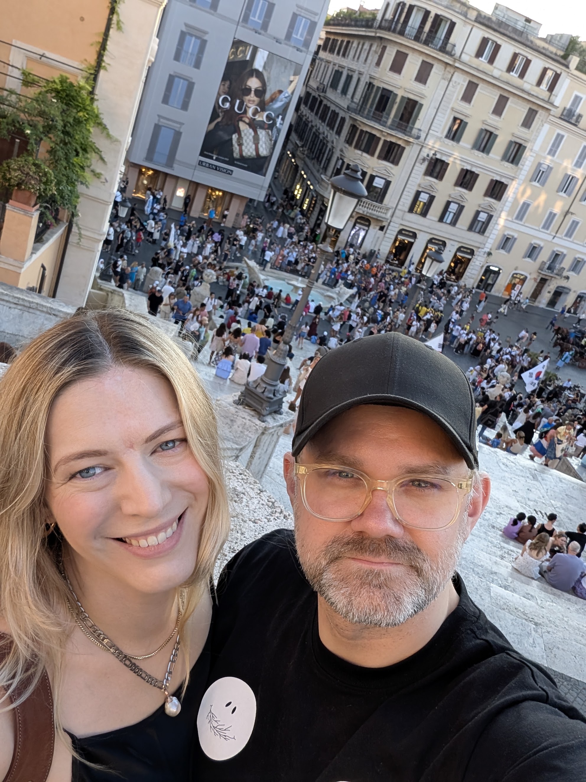 Sarah and Tommy smiling together on city steps